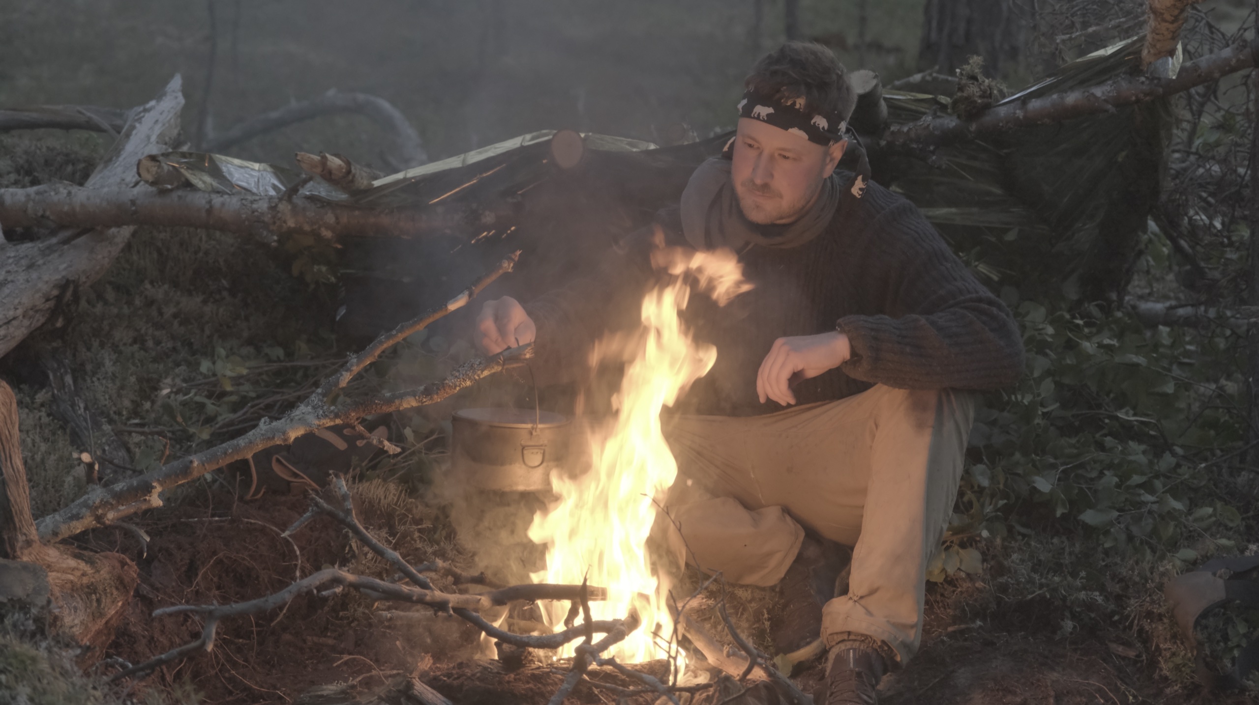 Sakke nuotion äärellä lean-to-suojassa